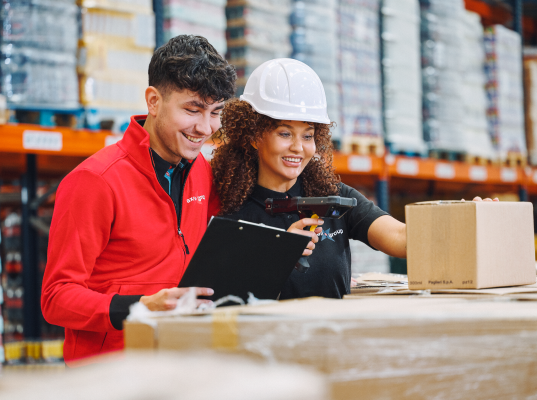 Two Axell warehouse workers handling fulfilment tasks, preparing customer orders for shipment.