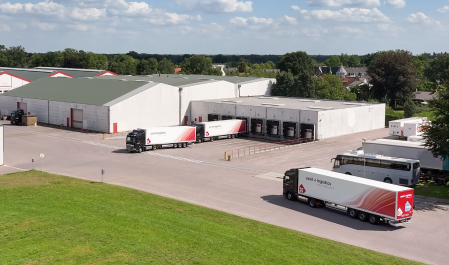 Drone view of Axell Logistics trucks inside a warehouse, prepared for international transport across Europe.