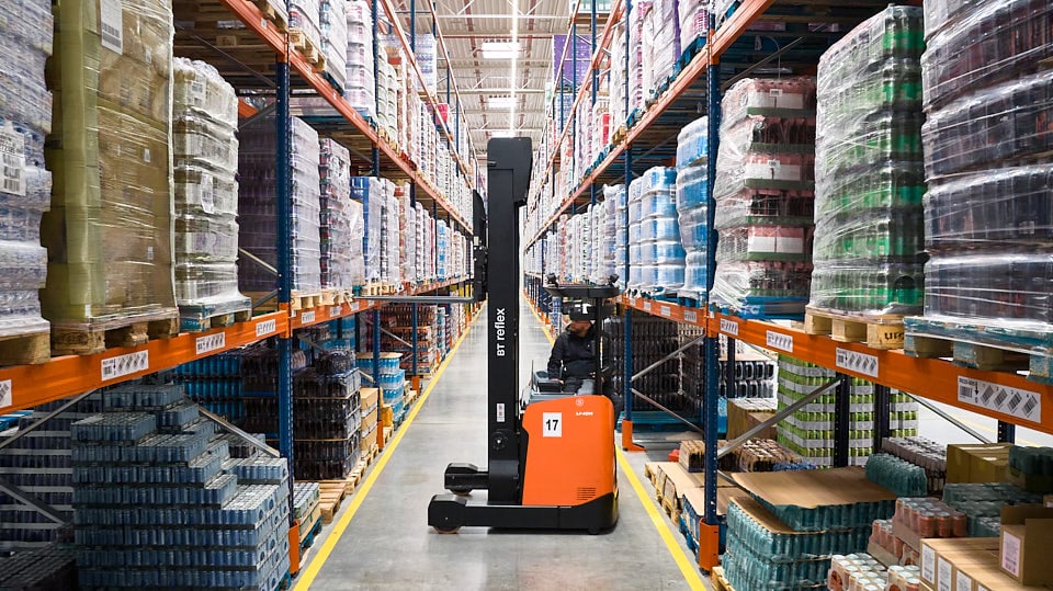 Wózek widłowy pracujący wewnątrz magazynu Axell podczas operacji magazynowych.