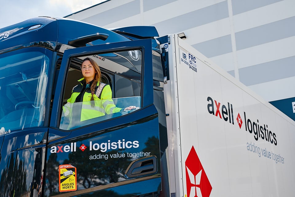 Kobieta-kierowca ciężarówki Axell Logistics prowadząca pojazd w transporcie międzynarodowym do Polski.