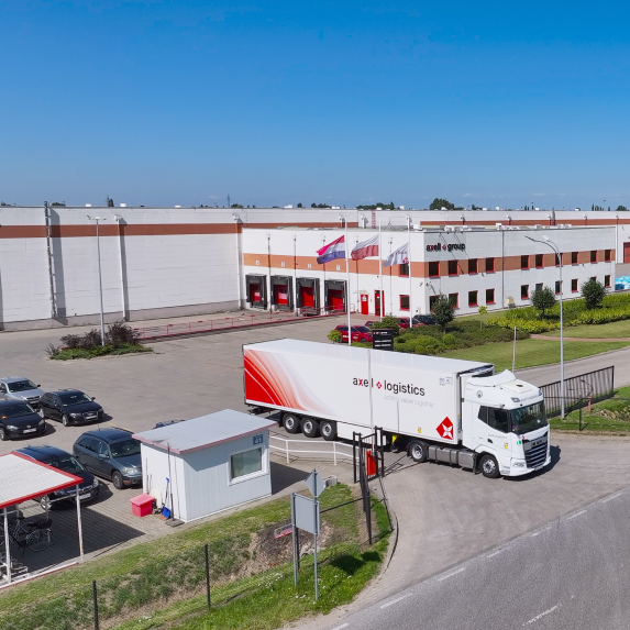 Ciężarówka Axell Logistics opuszczająca magazyn, gotowa do transportu międzynarodowego na terenie Europy, w tym Holandii i Polski.