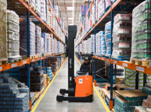 Wózek widłowy pracujący wewnątrz magazynu Axell podczas operacji magazynowych.